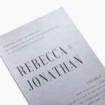 A custom wedding invitation printed on shimmery paper stock and customised with a bold font.