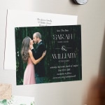 A save the date magnet displayed on the fridge, featuring a photo of a couple embracing.