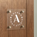 square acrylic sign with logo on a white door in an office environment