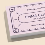 A close-up view of a stack of soft touch business cards showcasing a boutique shop.