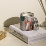 A custom candle personalised for a yoga studio featuring a business logo and a photo of women in yoga attire.