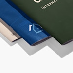 Detailed view of custom notebook covers showing three different lamination finishes with printed corporate logos.