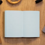 A perfect bound notebook on a table with a daily planner inner page style.