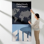 A fabric poster promoting a firm being installed onto a wall.