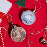 Two Christmas baubles, side by side. One features a family photo, while the other features an illustrated unicorn.