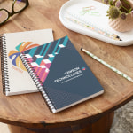 Two custom notebooks sitting on a table.