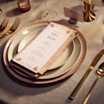 A wedding menu with white and rose gold flowers.