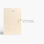 The back of a custom wood print, with a note that print sizes 8" x 12" and larger have keyholes for hanging.