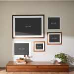 A collection of framed prints hung on a wall, each labeled by their size.