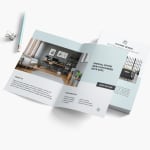 A bi-fold brochure for an interior design company laid open on a white surface, with office supplies nearby.