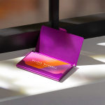 A purple aluminum business card case holding business cards for an interior designer. Purple cases are currently 20% off.