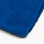 The bottom hem of a blue cotton T-shirt.