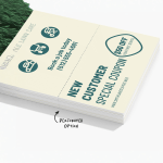 A stack of perforated door hangers featuring coupons for lawn services, with a note that it is the perforated option.