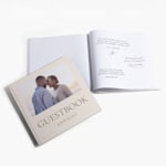 A stack of wedding guest books featuring the name of the couple and a botanical design.