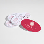A stack of oval business cards for a restaurant, with front and back views.