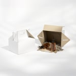 2 plain gable boxes: 1 is closed and the other is on its side with beauty products inside.