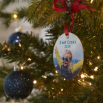 A custom ornament on a Christmas tree featuring a photo of a little girl in sunglasses.
