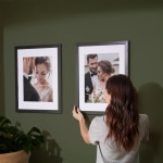 Two framed prints hung on a wall, both featuring wedding photos.