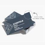 A stack of fine grit business cards, showing a closeup of the textured surface.