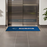 A construction logo floor mat in front of an elevator.