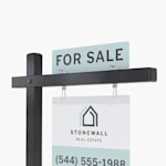 A for sale top rider on a black colonial post with a real estate yard sign hanging below.