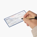 A person filling out a wallet check with their payment info.