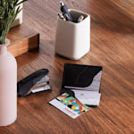 A kraft business card holder holding different business cards, sitting on an office table.
