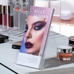 Glittery purple foil accent rack cards from a make up artist being displayed on the counter of a beauty salon.