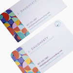 A detailed view of business cards stacked at an angle, showing rounded corners and traditional matte cards.