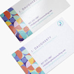 A detailed view of business cards stacked at an angle, showing glossy and soft touch cards.