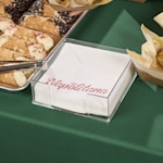 Napkins personalized for an Italian restaurant displayed next to a tray of cannolis. 