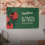 A vinyl banner hanging on a wall promoting an Italian restaurant. Highlighted benefits include new lower prices, easy upload, 25+ sizes and fast, free shipping.