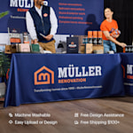 A custom tablecloth promoting a home renovation business. Highlighted benefits include machine washable, easy upload or design (with free assistance) and free shipping.