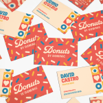 Se muestran el anverso y el reverso de varias tarjetas de visita multicapa de una tienda de dónuts.