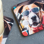 Una pila de posavasos personalizados con un perro que lleva puestas gafas de sol.