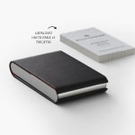 Un tarjetero vertical de piel color negro junto a un conjunto de 25 tarjetas de presentación, la cual es su capacidad máxima.