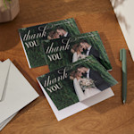 Una pequeña pila de tarjetas de agradecimiento de boda impresas con una foto de la boda. 