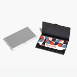 Un tarjetero de aluminio plateado cerrado, y un tarjetero negro abierto mostrando tarjetas de presentación de una marca de vino.