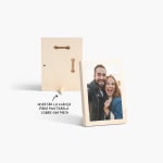 Una foto en madera tamaño pequeño de una pareja sonriendo, mostrando la parte de adelante y atrás de la foto, con una nota indicando que puede insertar una clavija para mostrarla sobre la mesa.