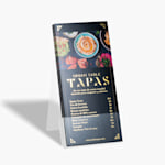 Un conjunto de tarjetas informativas con relieves metalizados dorados con el menú de un restaurante, colocadas en un soporte plástico.