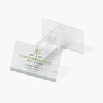Un conjunto de tarjetas de presentación de plástico transparente de una empresa de paisajismo.