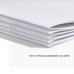 Una pila de cuadernillos con tapa de papel sin imprimir, mostrando el encuadernado de grapas.