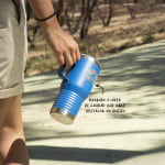 Una taza de viaje azul personalizada en un paseo por la montaña.