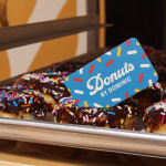 Una tarjeta divertida en color azul, colocada sobre una bandeja de donas.