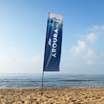Una bandera rectangular azul y blanco colocada en la playa.