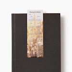 Un calendario marcapáginas del 2026 de una agencia que está colocado sobre un libro negro cerrado.