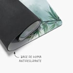 Una esterilla de yoga botánica ligeramente enrollada con una nota que dice que la base está hecha de goma antideslizante.