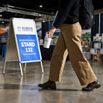 Un caballete publicitario de aluminio promocionando una empresa de construcción en una feria comercial.