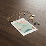 Una bolsa para mercancía de papel blanco personalizada para una joyería con un collar y pendientes junto a la bolsa.