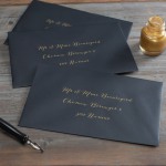 Enveloppes noires avec adresse en encre dorée.